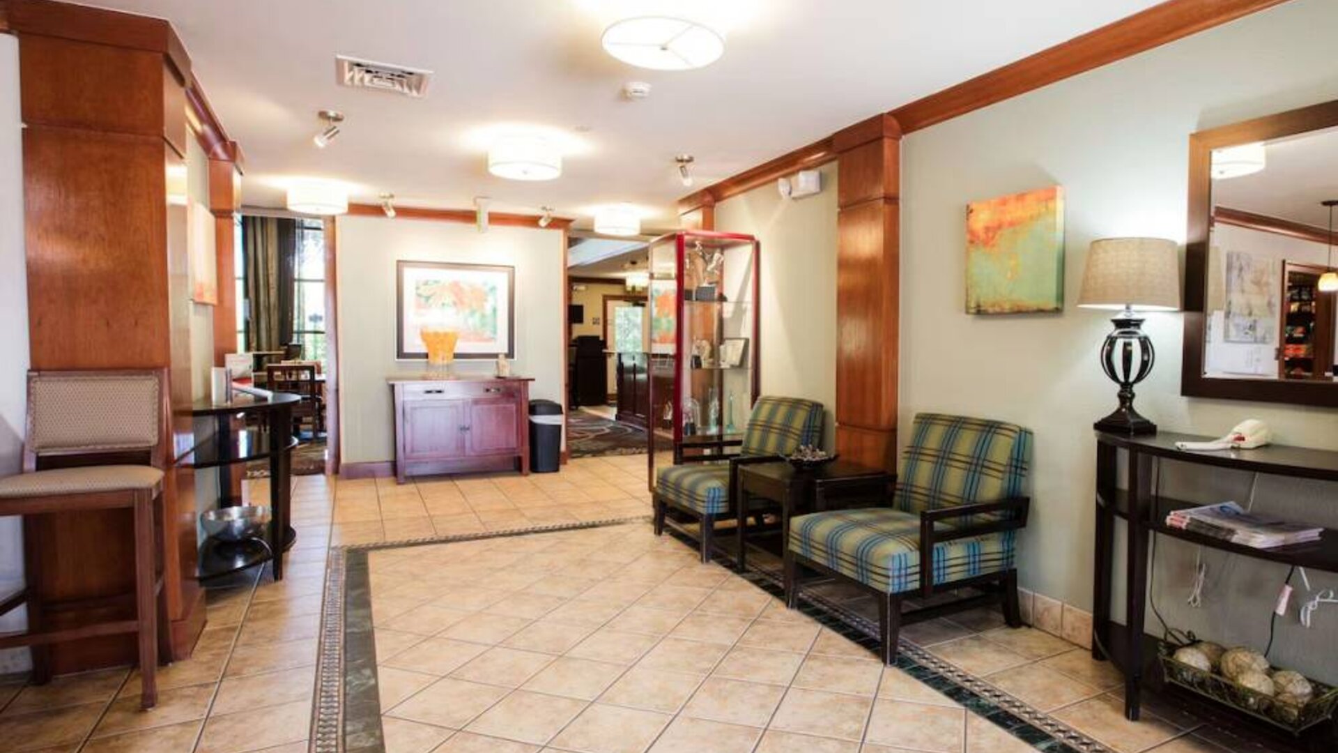 Sonesta ES Suites Austin The Domain Area’s lobby has a pair of armchairs, a coffee table, and art on the walls.