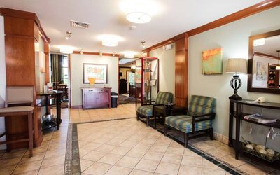 Sonesta ES Suites Austin The Domain Area’s lobby has a pair of armchairs, a coffee table, and art on the walls.