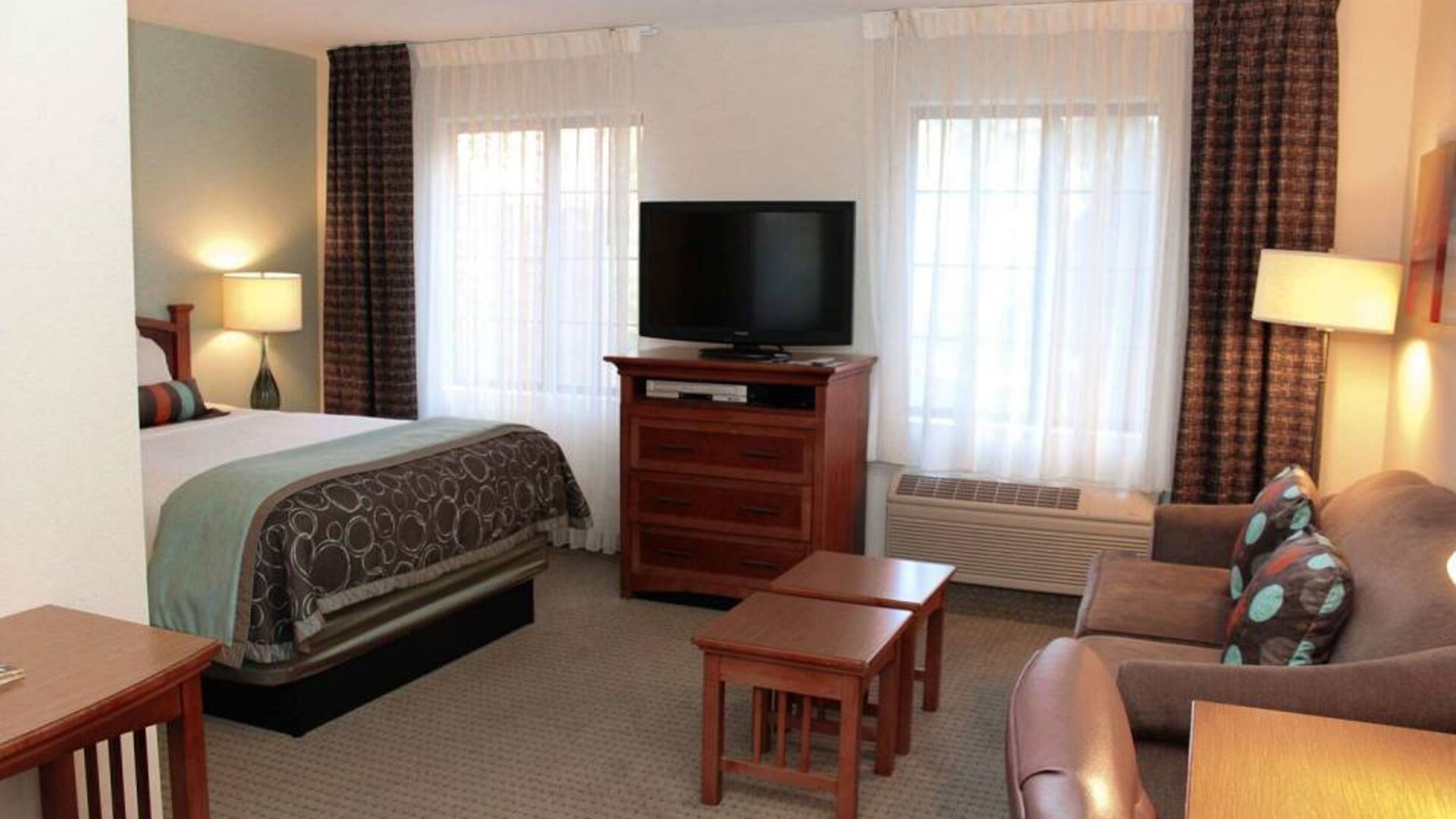 Double bed guest room in Sonesta ES Suites Portland Vancouver 41st Street, including lounge area with sofa, TV, and coffee tables.