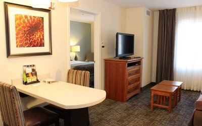 Sonesta ES Suites Portland Vancouver 41st Street guest room, furnished with double bed, desk and chairs, and a widescreen TV.