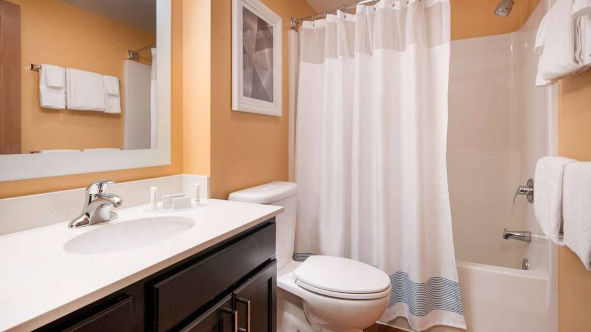 Sonesta Simply Suites Seattle Renton guest bathroom, furnished with bath and shower, lavatory, and mirror and sink.