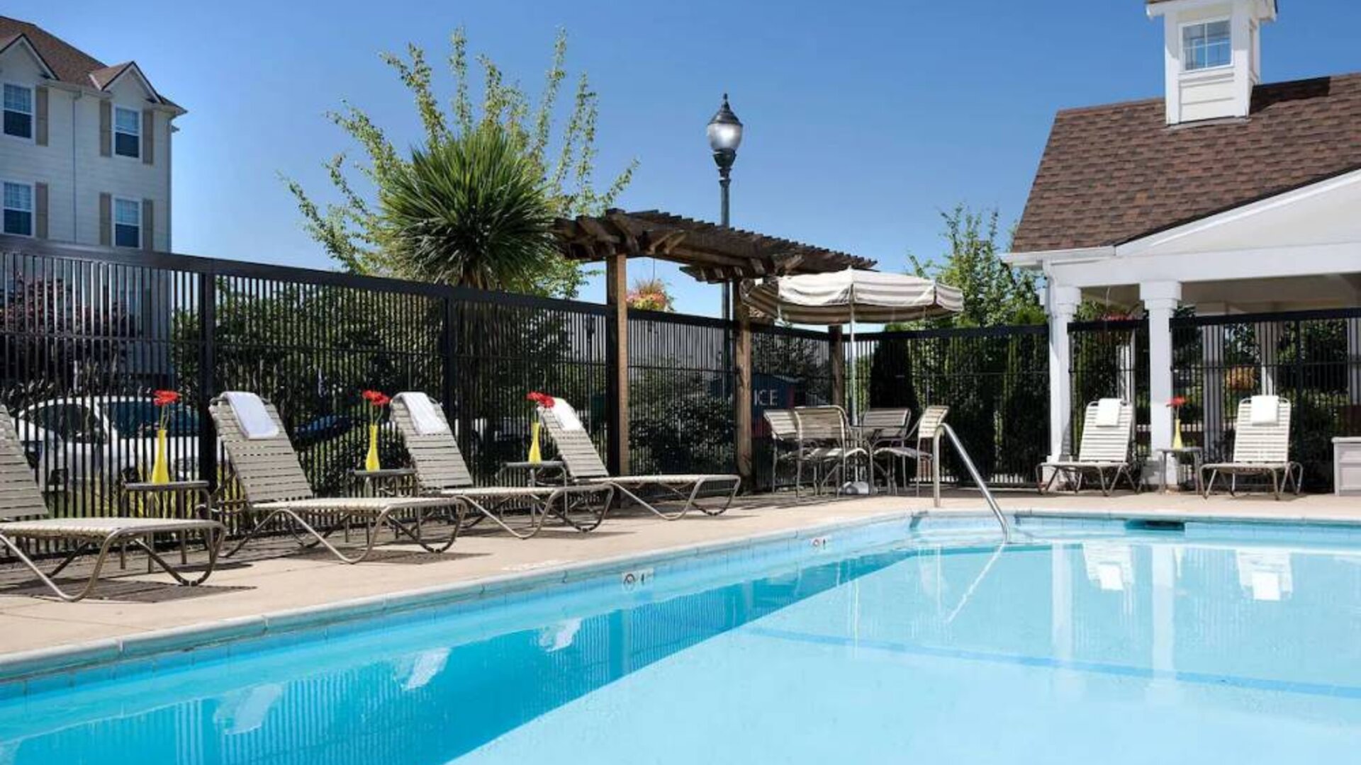 Sonesta Simply Suites Seattle Renton’s outdoor pool is fenced off and has both sun loungers and chairs by the side.