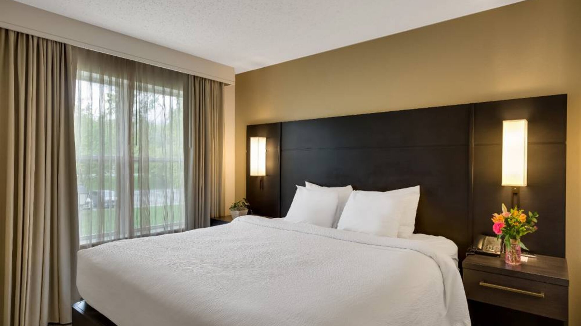 Double bed guest room in Sonesta ES Suites Parsippany Morris Plains, with bedside lighting and a large window.