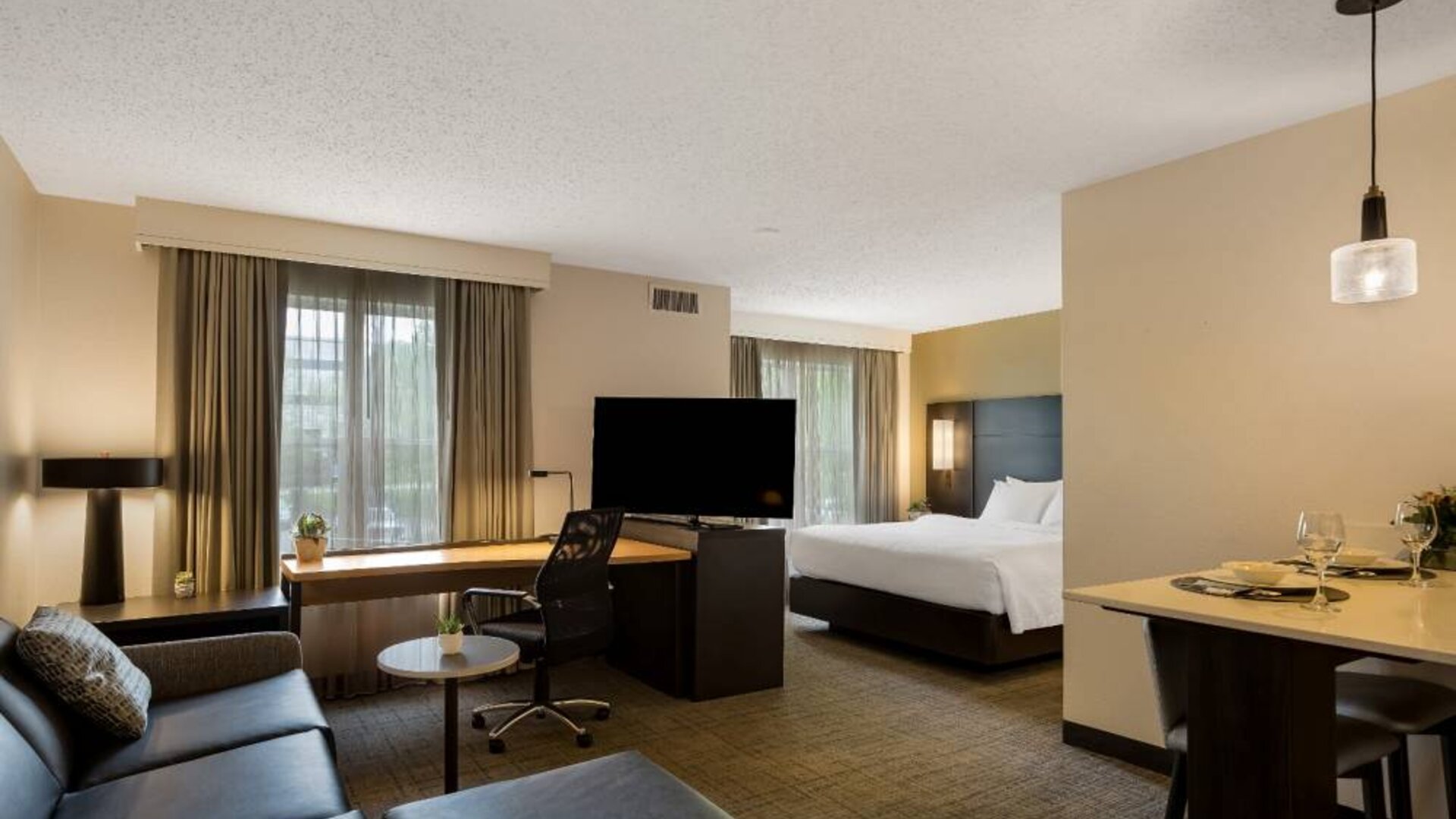 Sonesta ES Suites Parsippany Morris Plains double bed guest room, including TV and sofa, with a workspace desk and chair.