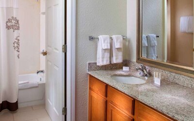 Sonesta ES Suites Birmingham Homewood guest bathroom, with sink, mirror, and bath (including shower).