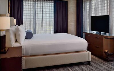 Sonesta Bee Cave Austin double bed guest room, including large windows and a widescreen TV.