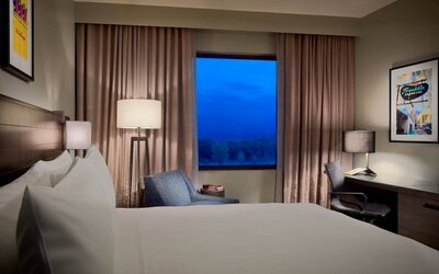 Double bed guest room in Sonesta Bee Cave Austin, with a window and workspace desk, lamp, and chair.