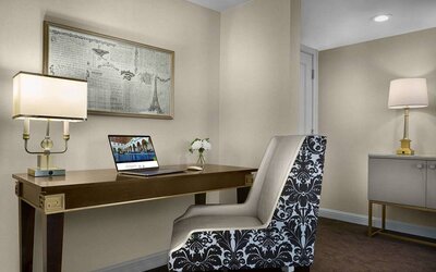 The Chase Park Plaza Royal Sonesta St. Louis guest room workspace, furnished with desk, chair, and lamp.