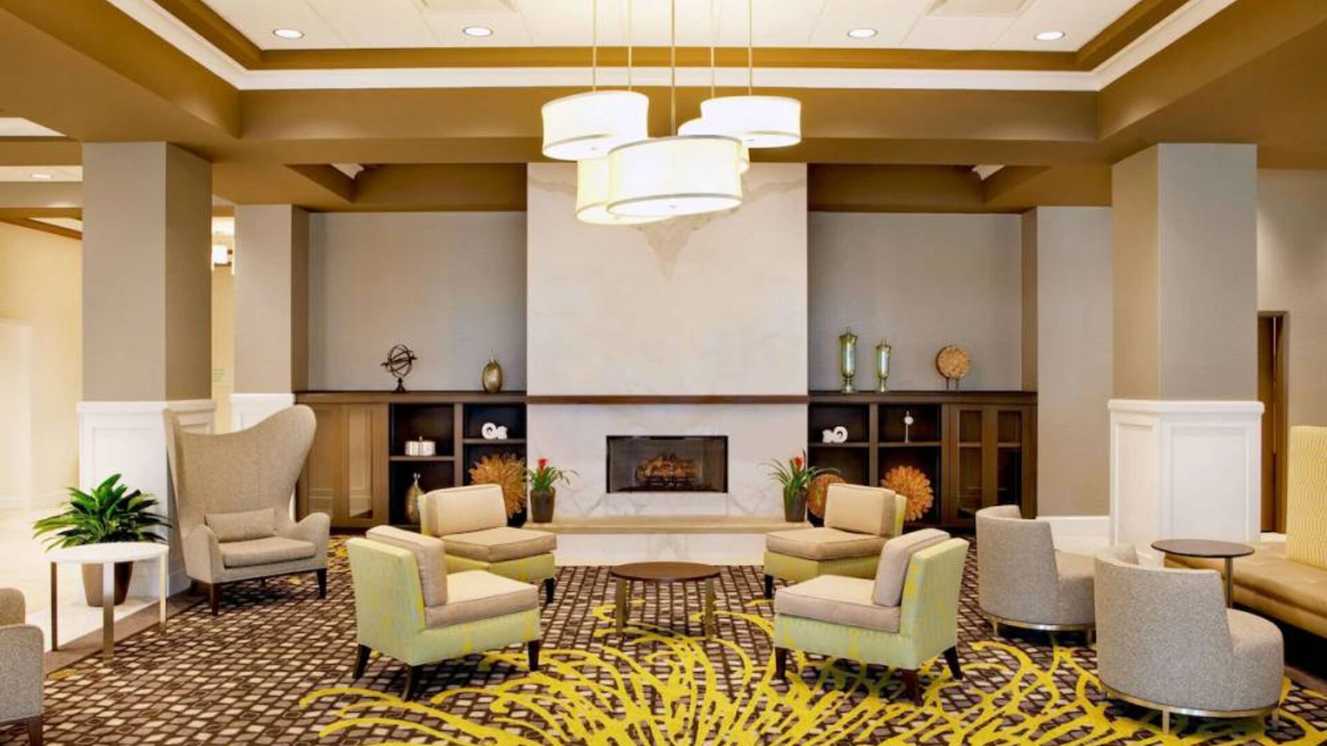 The hotel’s lobby lounge includes a fireplace, armchairs and coffee tables set in a spacious environment.
