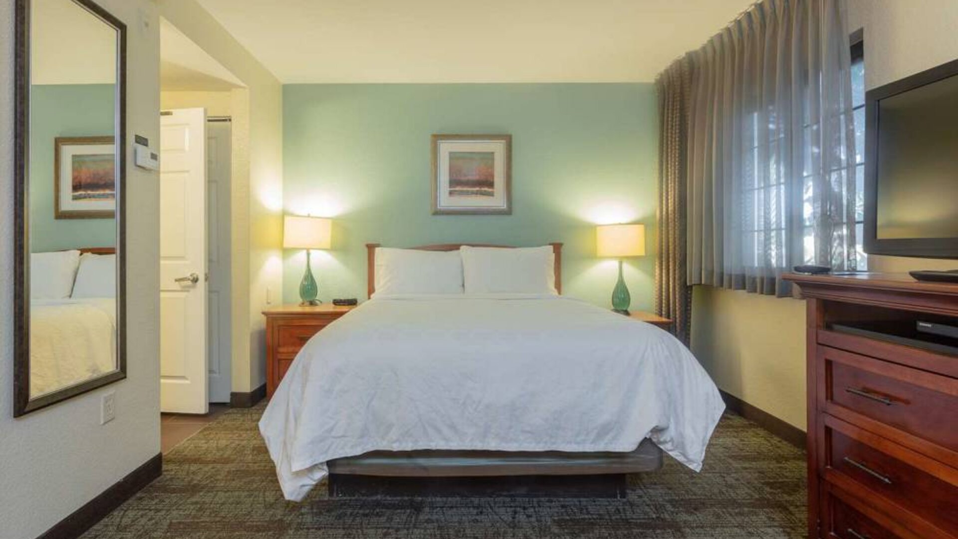 Sonesta ES Suites Anaheim Resort Area double bed guest room, featuring art on the wall, TV, and a window.