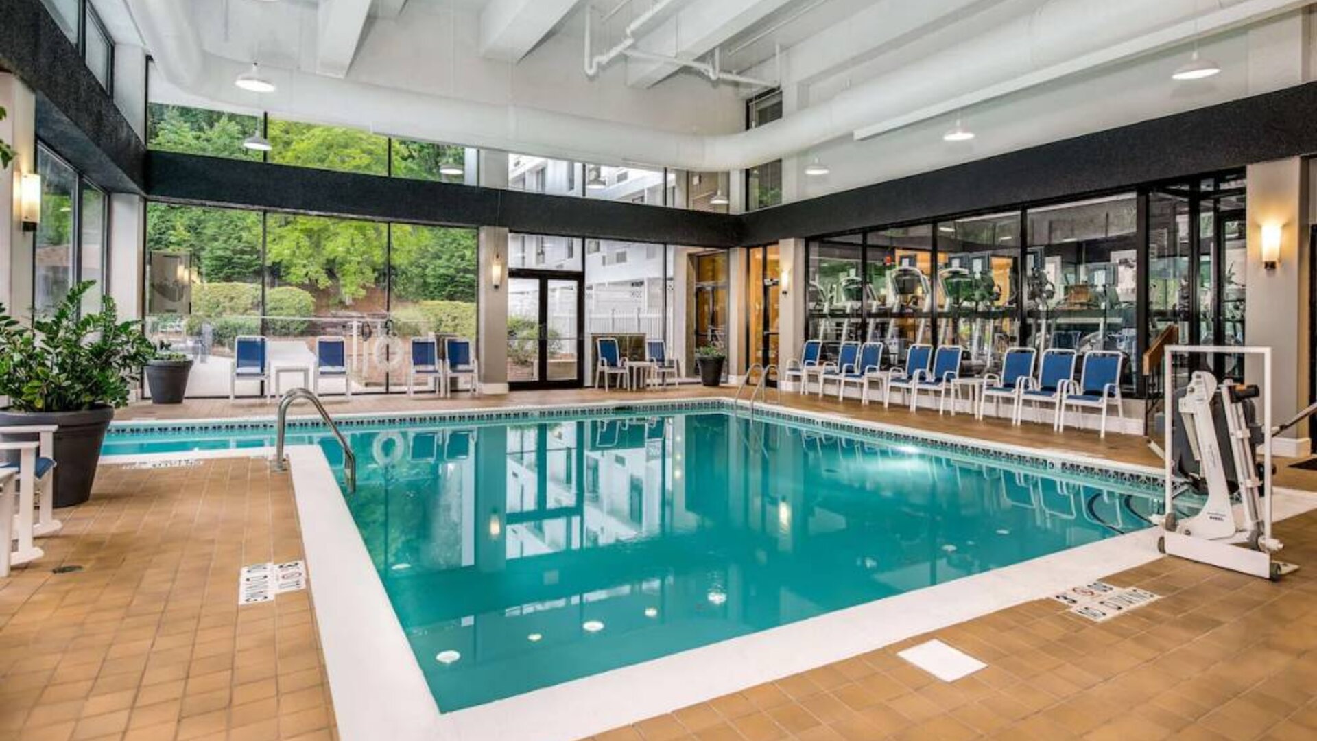 The hotel’s indoor pool includes a lift, has chairs by the side, and large windows to let in plenty of natural light.