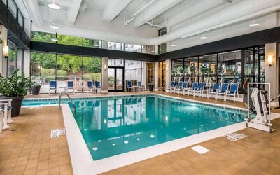 The hotel’s indoor pool includes a lift, has chairs by the side, and large windows to let in plenty of natural light.