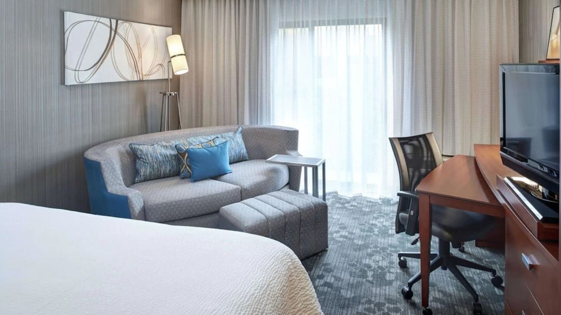 Delux king room with couch and workspace at Sonesta Select Milwaukee Brookfield.