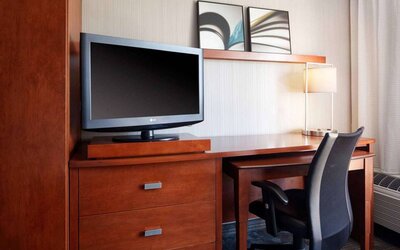Sonesta Select Newport Middletown guest room workspace, including desk, chair, lamp, and TV.