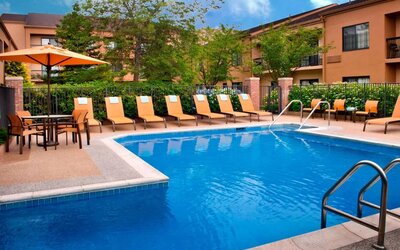 The hotel’s outdoor pool has a direct water link to the indoor pool, and has a shaded table and chairs as well as sun loungers by the side.