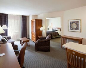 Double bed guest room in Sonesta ES Suites San Antonio Northwest - Medical Center, featuring sofa and armchair, plus workspace desk and chair.