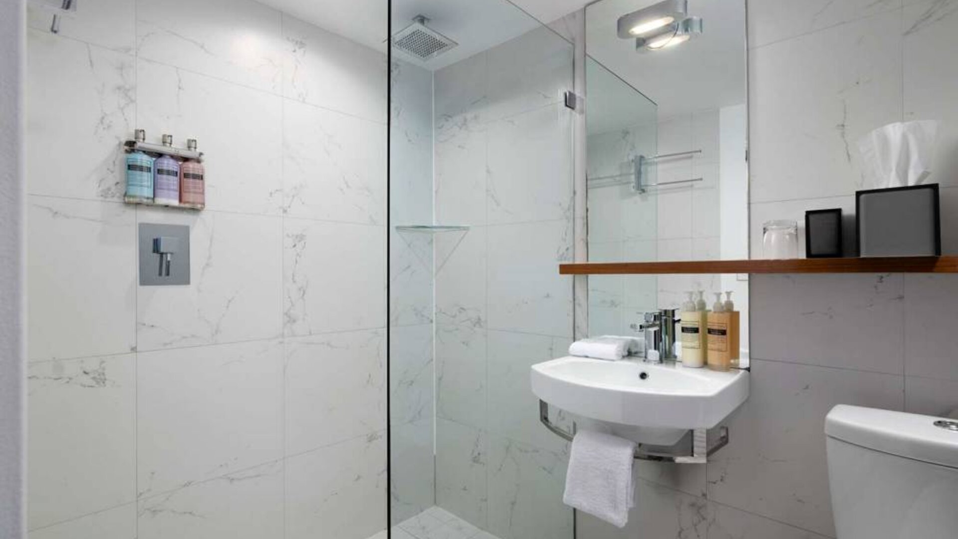 Guest bathroom in Nautilus by Sonesta, including shower, sink, mirror, and lavatory.