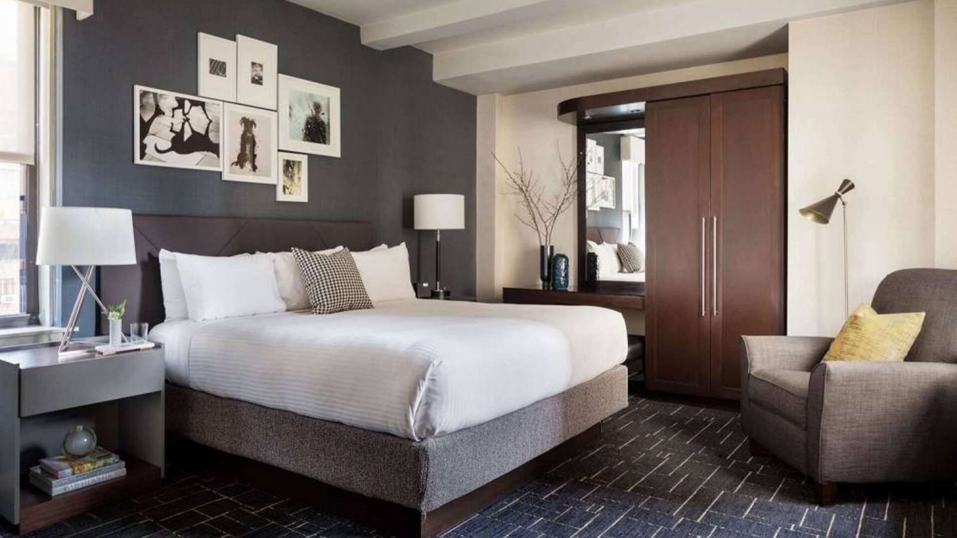 Double bed guest room in The Shelburne Sonesta New York, furnished with bedside lamp, wardrobe, and armchair.