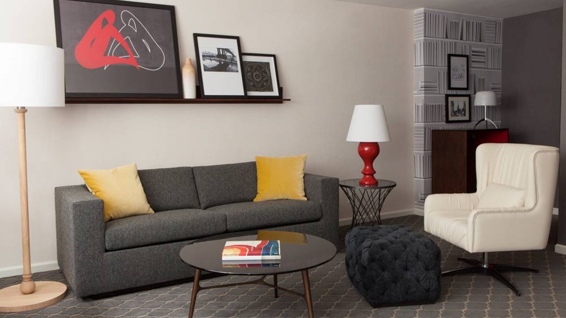 The Fifty Sonesta Select New York guest room living area, furnished with sofa, chair, coffee table, and artwork.