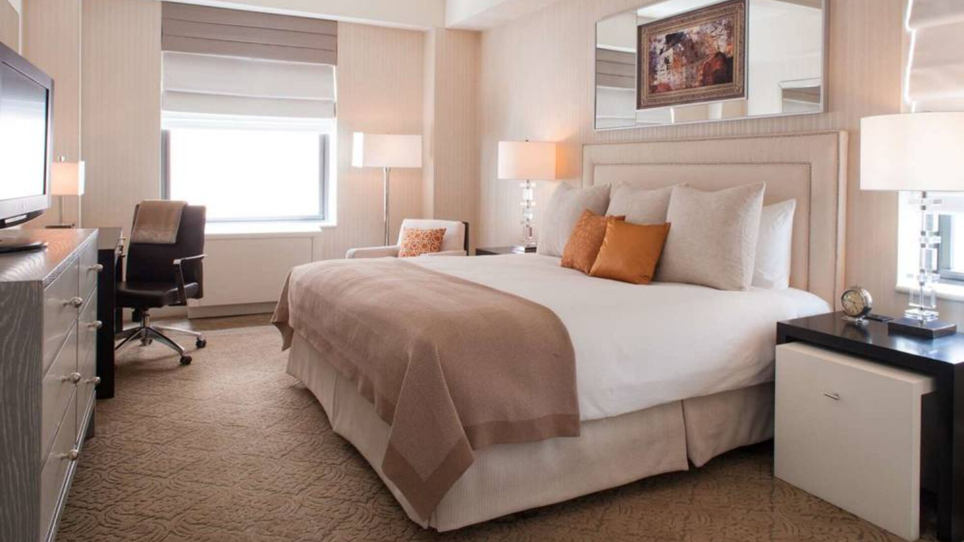 The Benjamin Royal Sonesta New York double bed guest room, including TV, chair, armchair, and window.