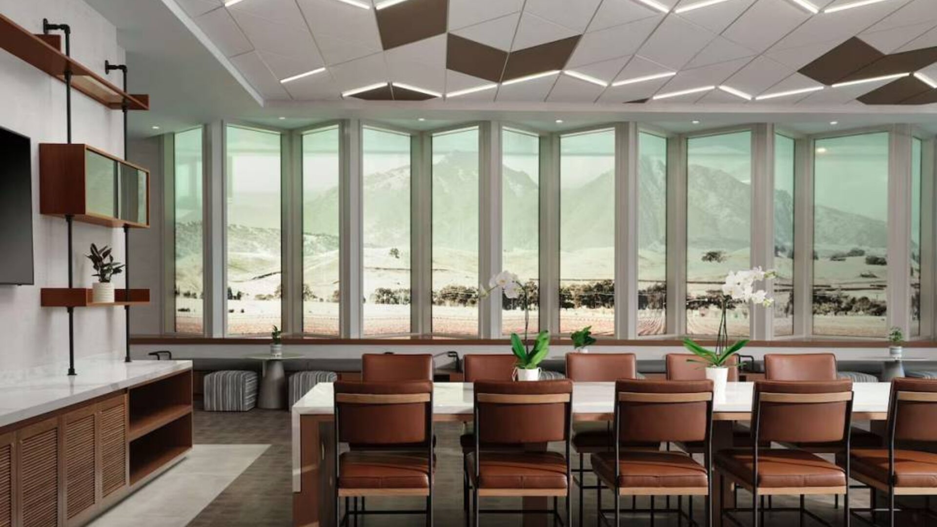 Hotel meeting room, including long table, high ceiling, large windows, and a wall-mounted television.