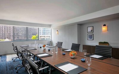 Royal Sonesta Chicago Downtown meeting room, including long table and swivel chairs, with views of the urban landscape.