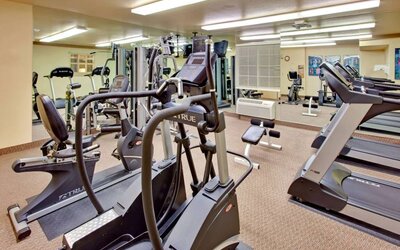 Sonesta Simply Suites Phoenix Tempe’s fitness center has a mirrored wall and a range of exercise equipment.