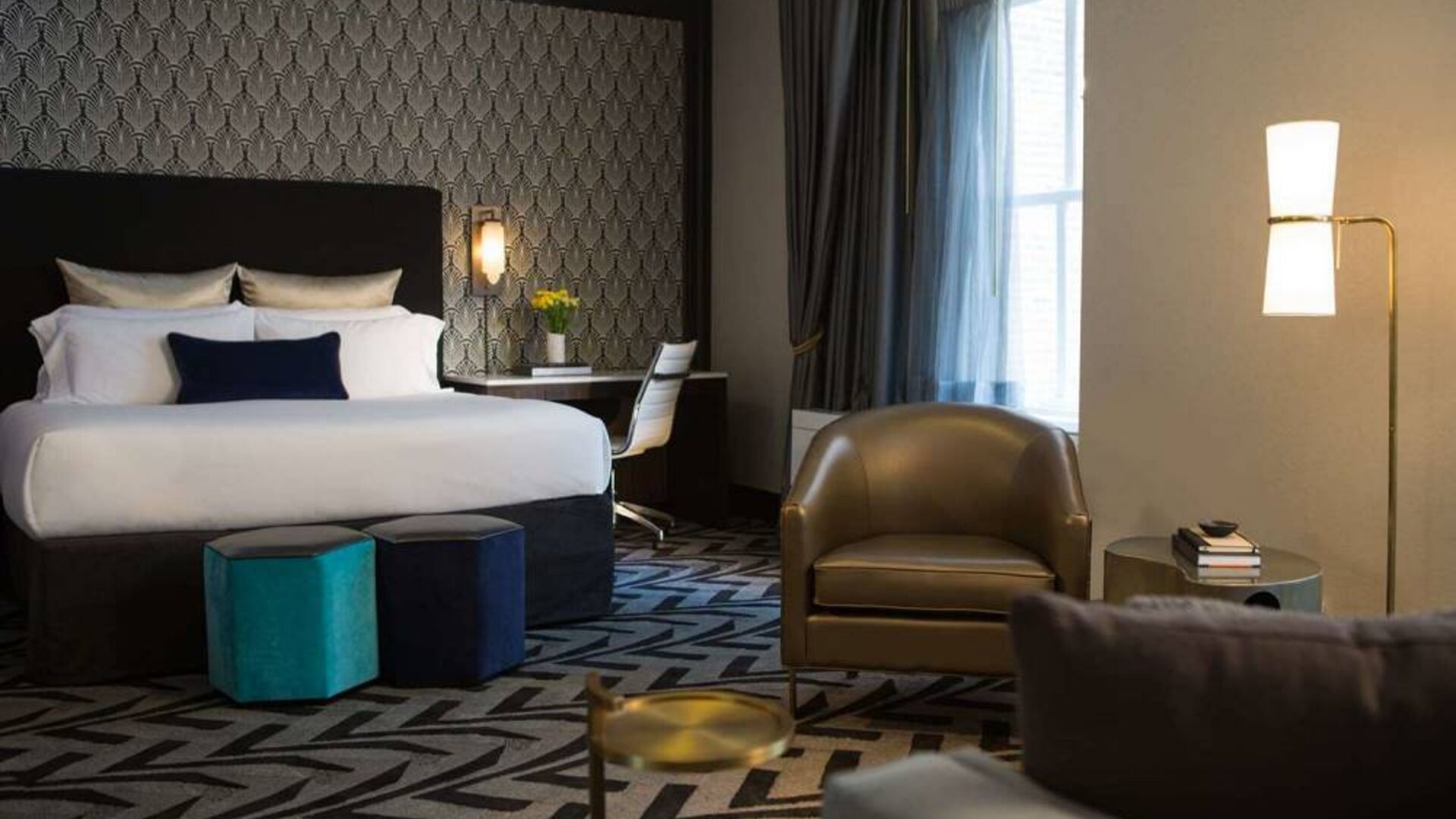 The Allegro Royal Sonesta Hotel Chicago Loop double bed guest room, furnished with workspace desk and chair, window, and an armchair and coffee table.