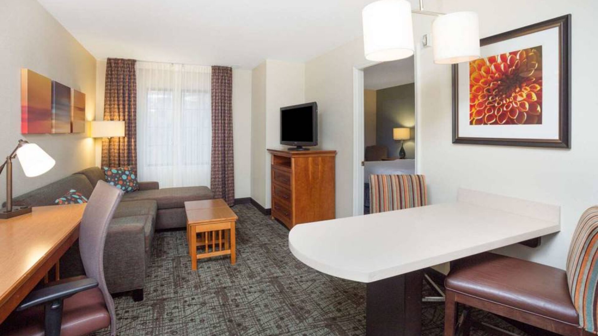 Sonesta ES Suites Atlanta - Perimeter Center double bed guest room, with living area that has a desk and chair, sofa, coffee tables, window, and TV.