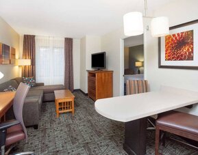 Sonesta ES Suites Atlanta - Perimeter Center double bed guest room, with living area that has a desk and chair, sofa, coffee tables, window, and TV.