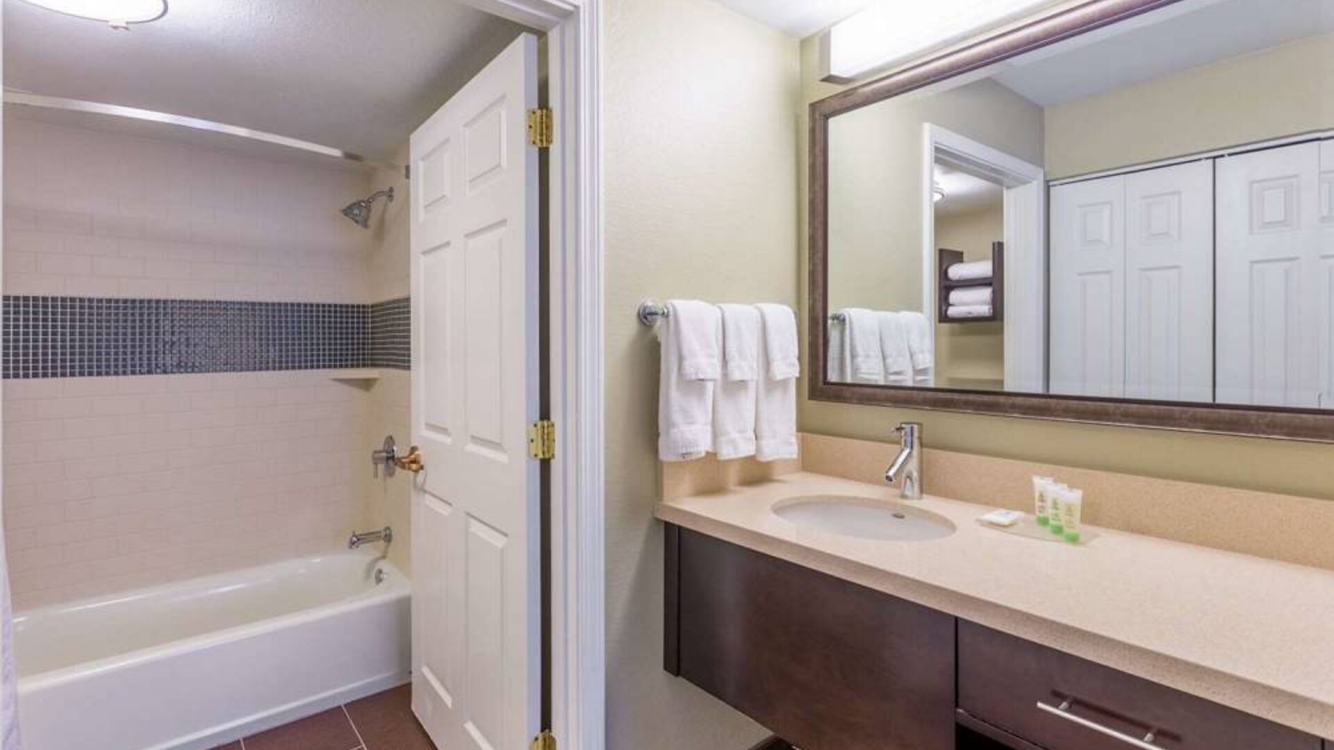 Guest bathroom in Sonesta ES Suites Atlanta - Perimeter Center, with shower and bath, sink and mirror.