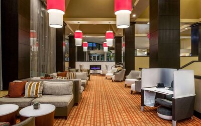 Sonesta White Plains Downtown’s lobby lounge is furnished with sofa and armchair seating, coffee tables, and a fireplace.