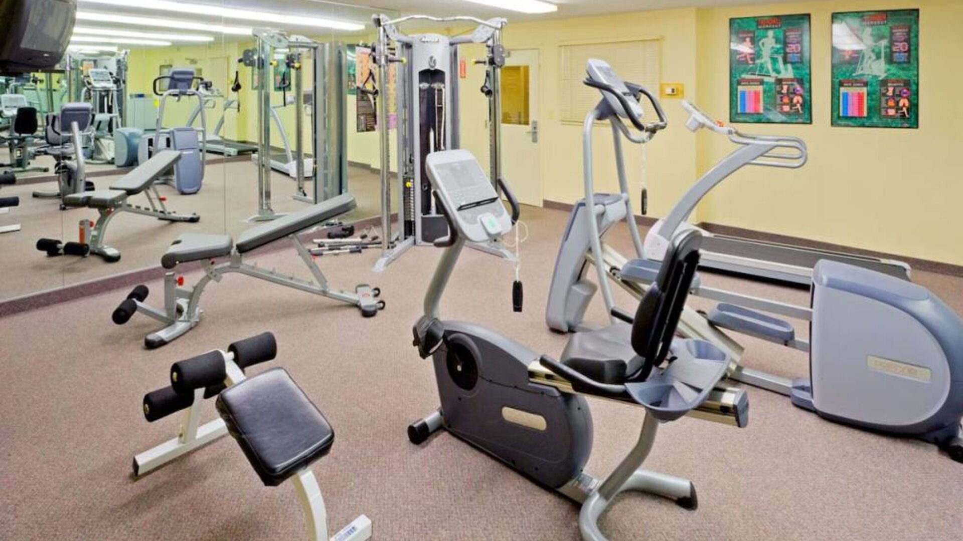 Sonesta Simply Suites Parsippany Morris Plains’ fitness center is equipped with assorted exercise machines, a mirrored wall, and a TV.