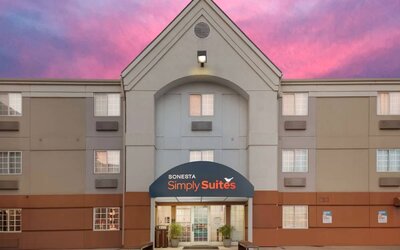The hotel’s exterior includes potted plants by the front door, above which is the name Sonesta Simply Suites.