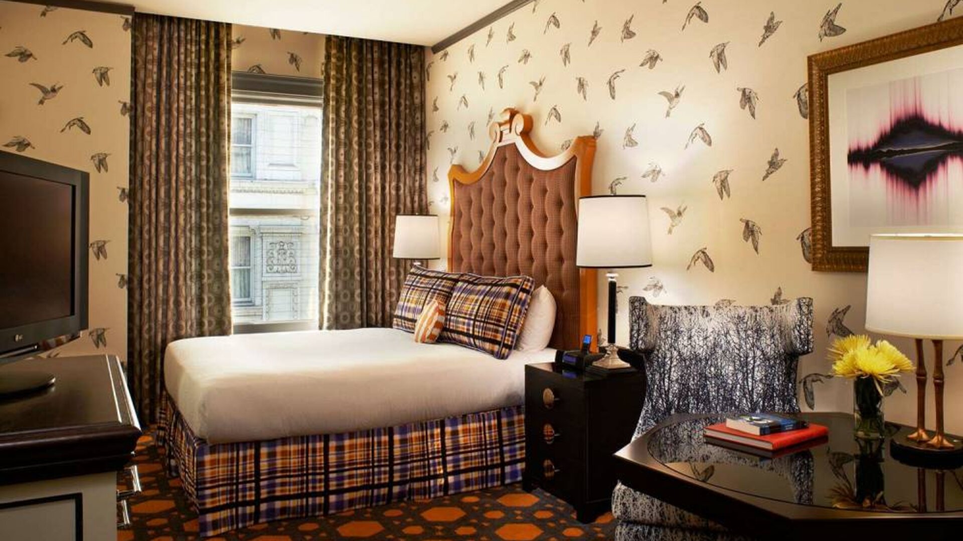 Royal Sonesta Portland Downtown double bed guest room, with chair, coffee table, TV, and window.