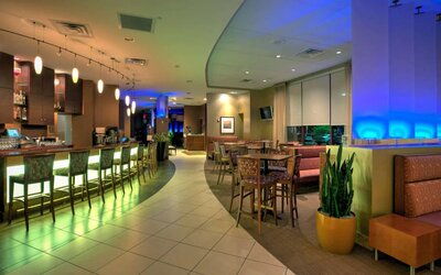 The hotel’s dining area has a mix of bar stool seating and tables and chairs, with subdued lighting providing a relaxed atmosphere.