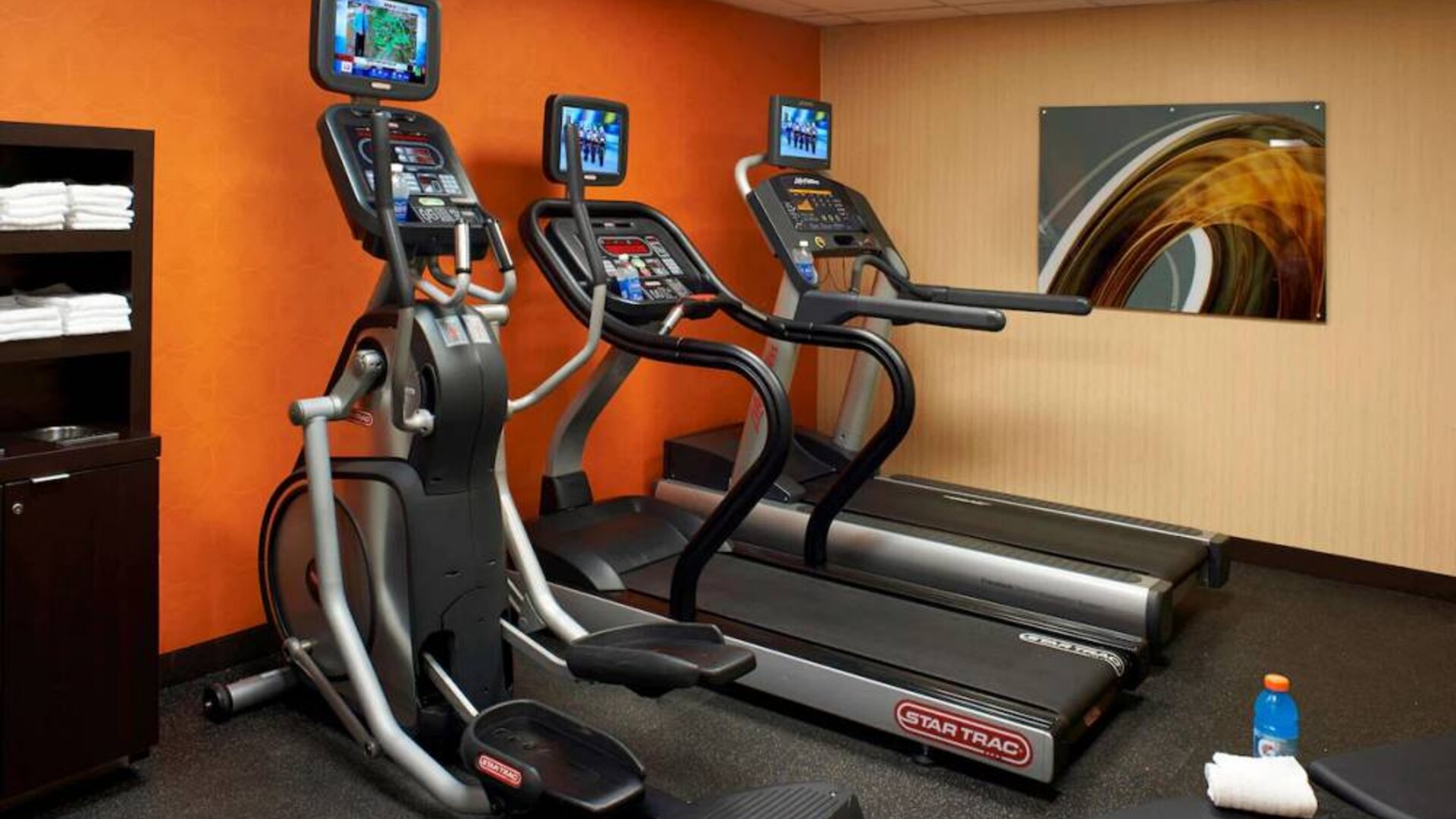 The hotel fitness center has art on the wall and a range of exercise equipment, including treadmills and an elliptical.