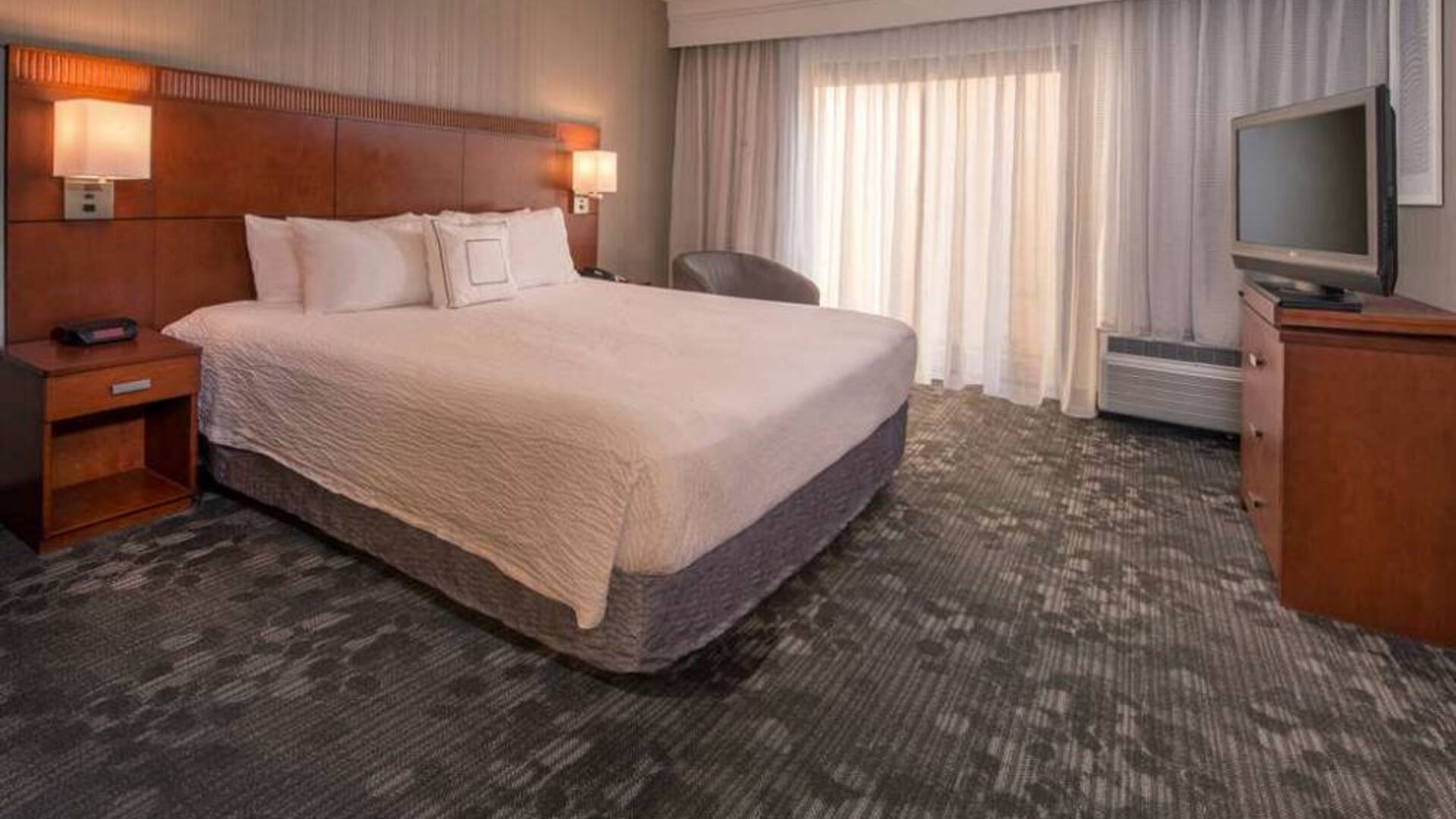 Double bed guest room in Sonesta Select Columbia, including a large window, chair, and TV.