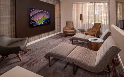 The hotel’s lobby features reclined seats facing a large, wall-mounted TV.