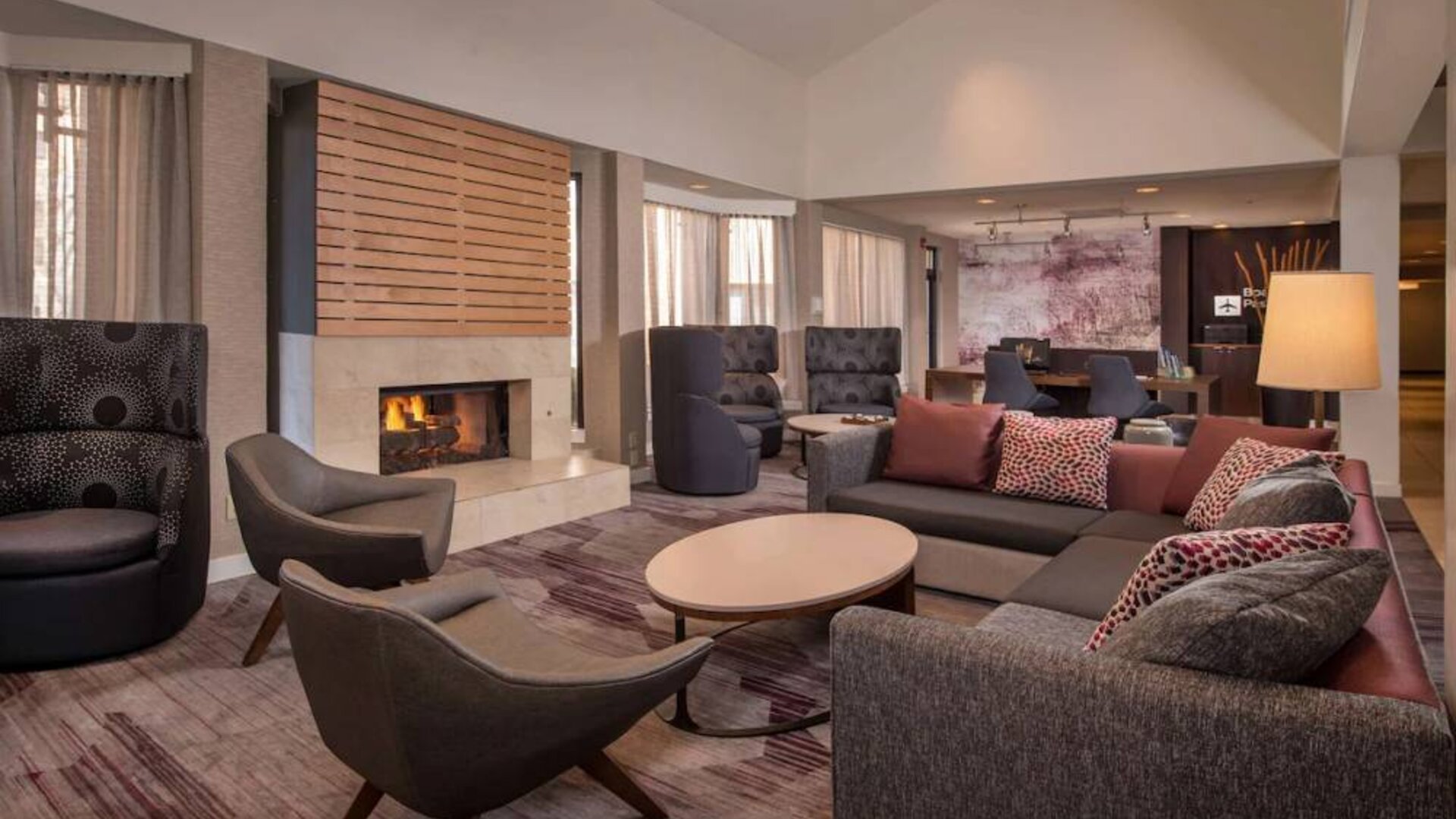Sonesta Select Columbia’s lobby lounge is furnished with a large sofa and comfy chairs, coffee tables, and a fireplace.