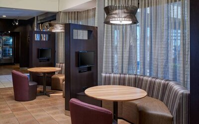 Sonesta Select Indianapolis Carmel’s media pods each feature a TV, coffee table, and comfortable seating next to a window.