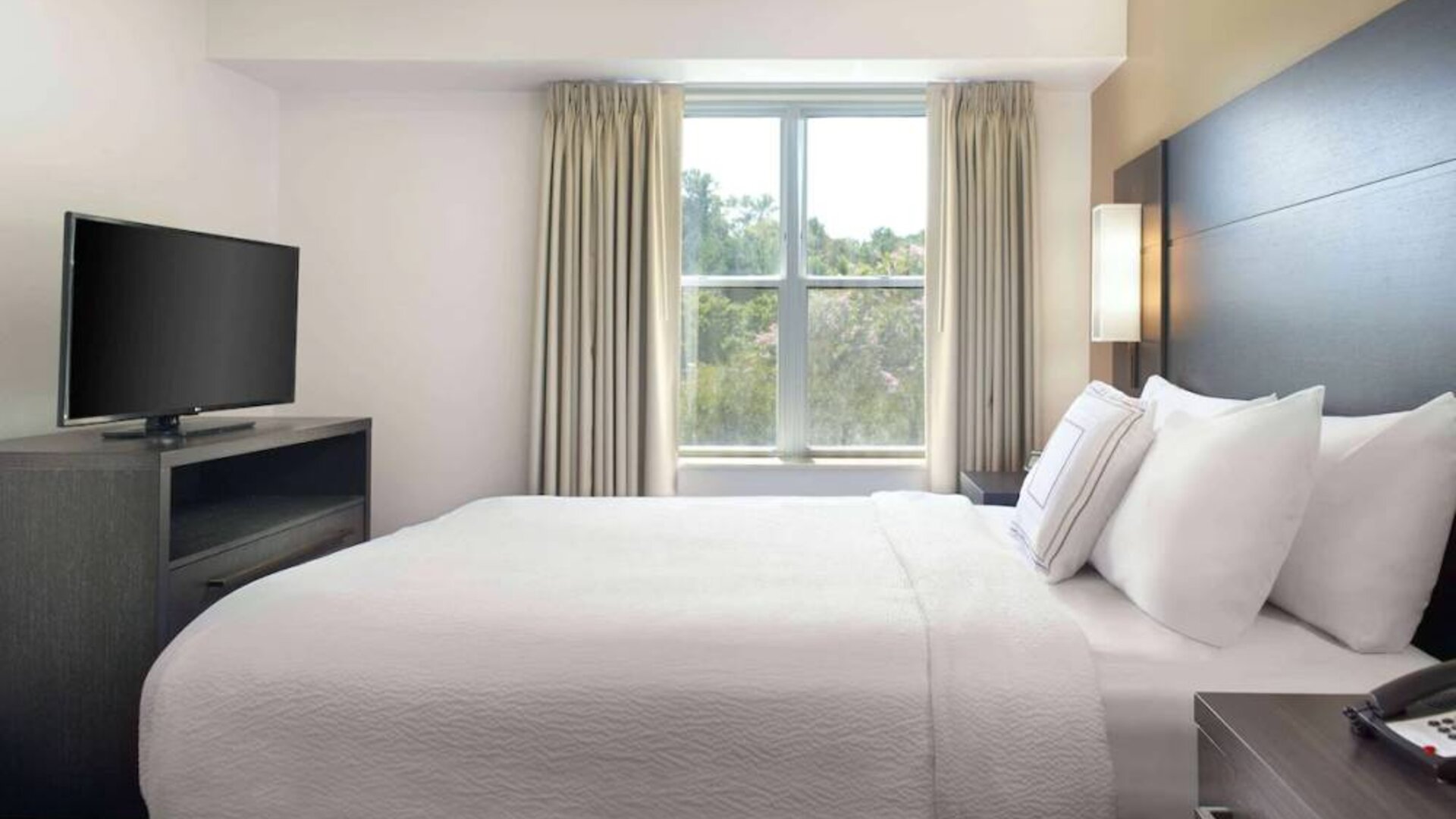 Sonesta ES Suites Raleigh Cary double bed guest room, including window and widescreen television.