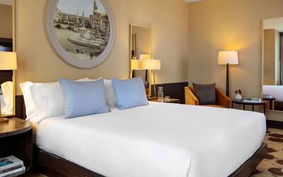 Royal Sonesta Chicago River North double bed guest room, furnished with bedside lamps, coffee table, and an armchair.