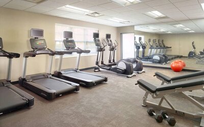 Sonesta ES Suites Raleigh Durham Airport Morrisville’s fitness center is equipped with free weights, benches, and various exercise machines.
