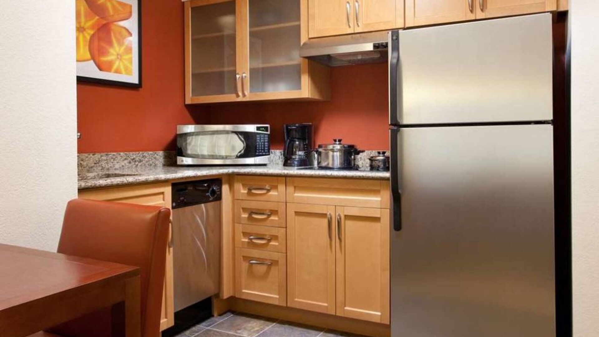 Guest room kitchen fitted with microwave, fridge-freezer, hob, and table at Sonesta ES Suites San Antonio Downtown Alamo Plaza.