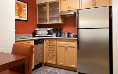 Guest room kitchen fitted with microwave, fridge-freezer, hob, and table at Sonesta ES Suites San Antonio Downtown Alamo Plaza.