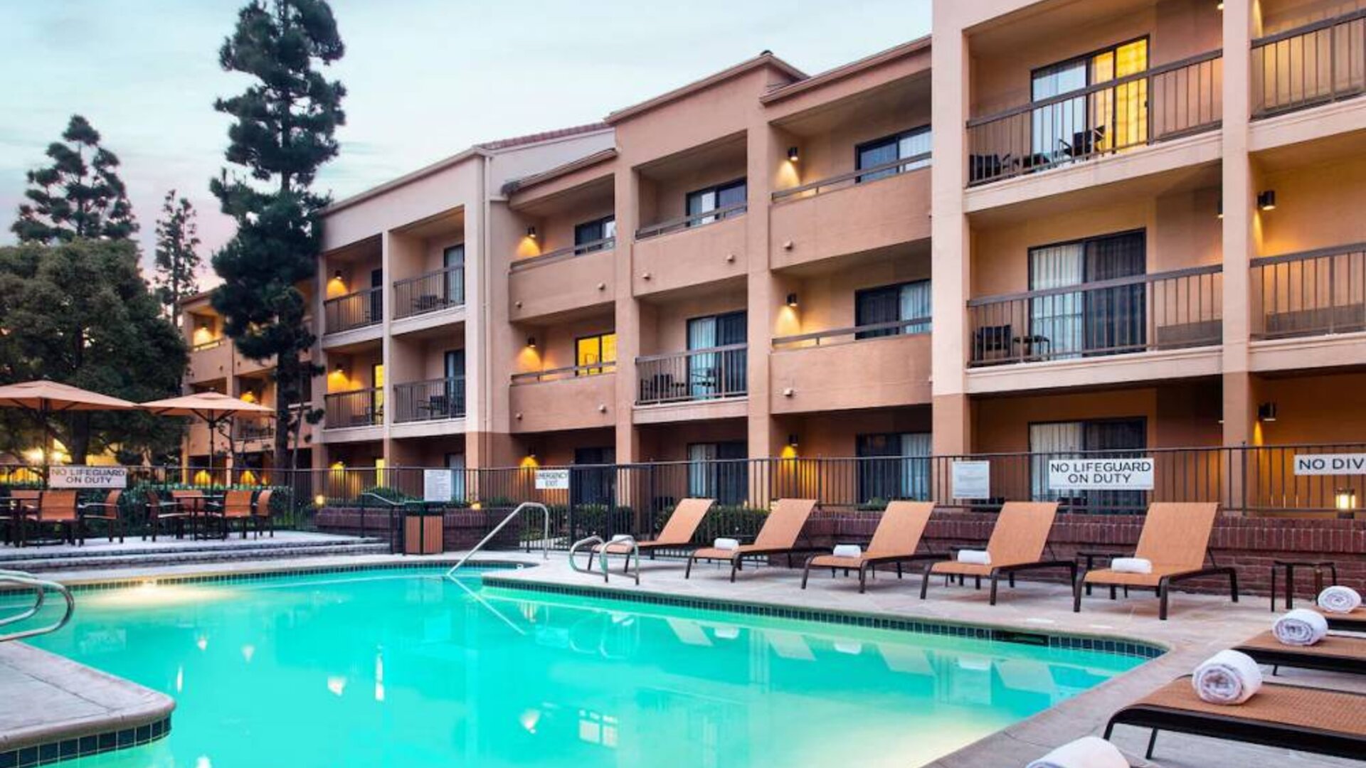 Sonesta Select Los Angeles LAX El Segundo’s outdoor pool has shaded tables and chairs, as well as sun loungers, by the side.