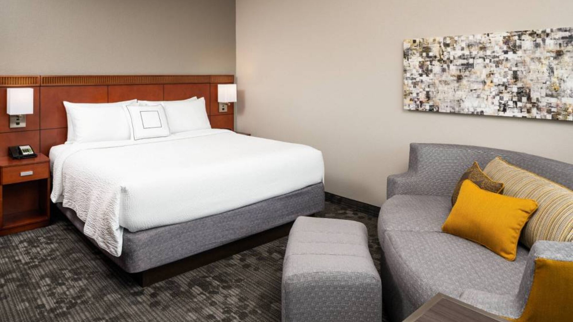 Double bed guest room in Sonesta Select Miami Lakes, featuring art on the wall and a sofa.