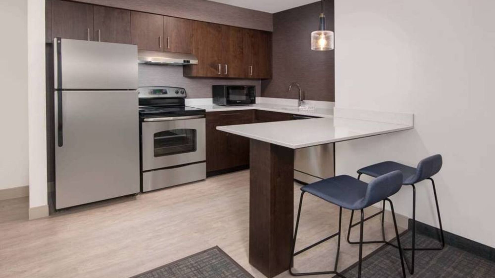 Sonesta ES Suites Atlanta Alpharetta North Point Mall guest room kitchen, fitted with fridge-freezer, microwave, oven, and table.