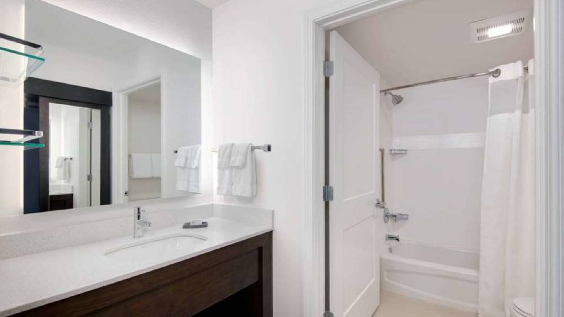 Guest bathroom in Sonesta ES Suites Atlanta Alpharetta North Point Mall featuring shower-equipped bath, lavatory, mirror, and sink.